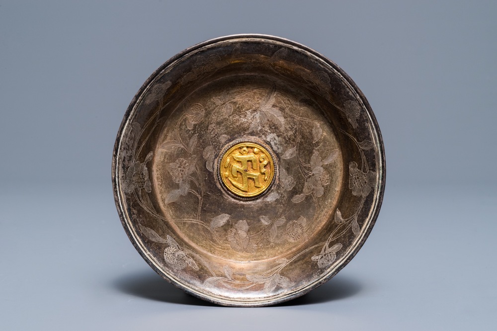 A Sino-Tibetan engraved silver dish with gilt central medallion, 19/20th C.