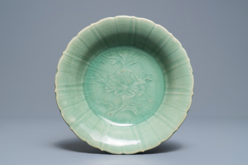 Een Chinees Longquan celadon bord met onderglazuur pioendecor, Ming