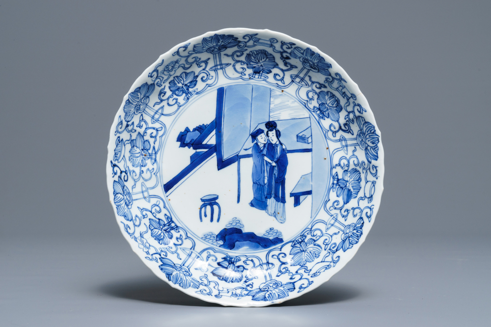 A Chinese blue and white moulded plate with an amorous couple, Kangxi mark and of the period