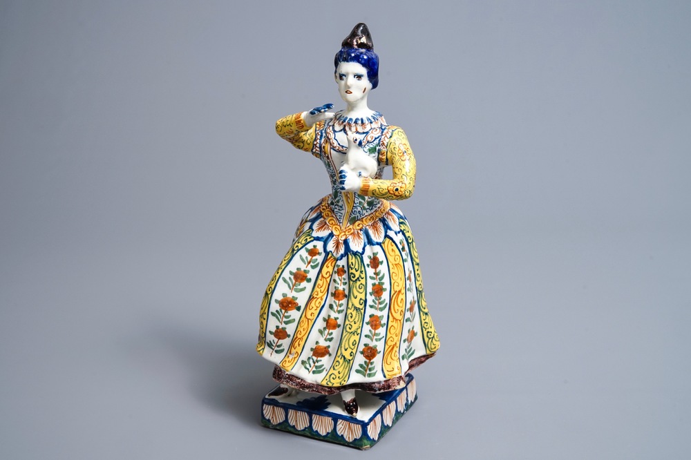 A large polychrome Dutch Delft model of a lady with a dog, 18th C.