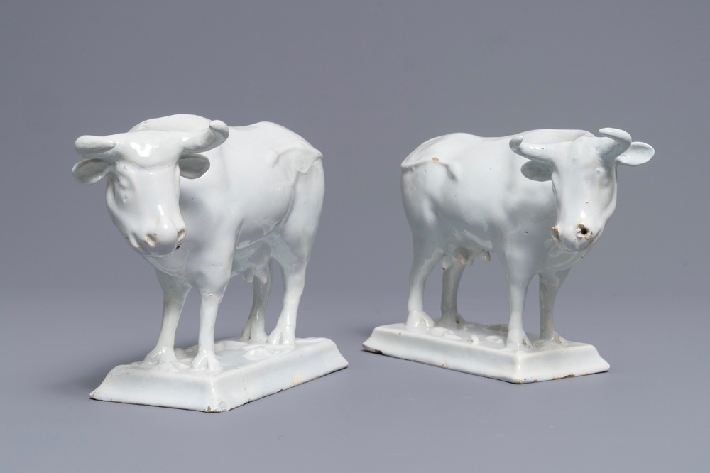 A pair of white Dutch Delft models of cows on bases with frogs, 18th C.