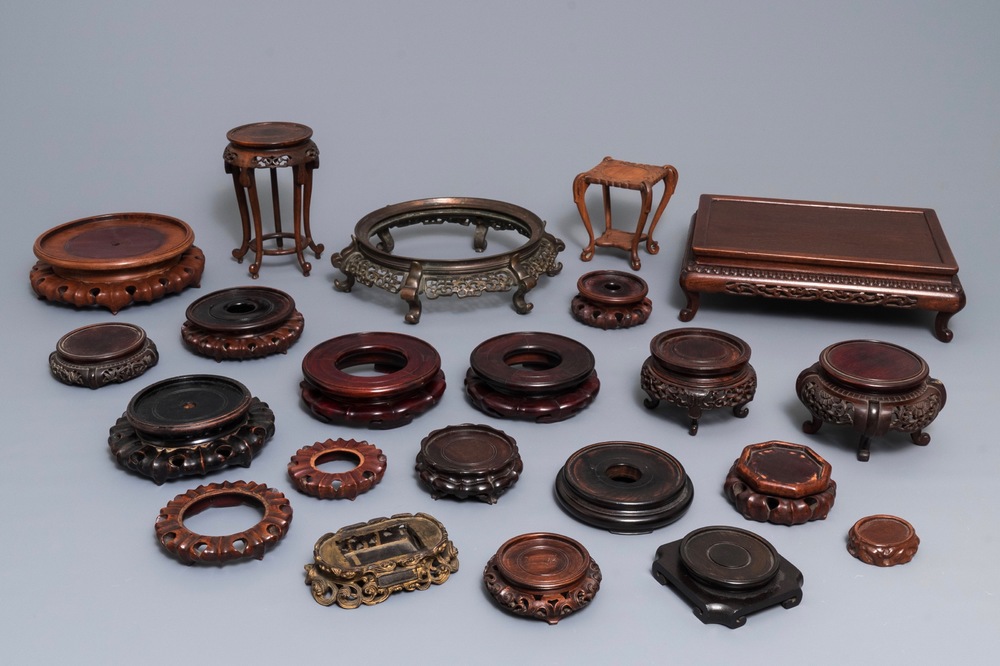 A collection of 22 Chinese wooden stands and one in bronze, 19/20th C.