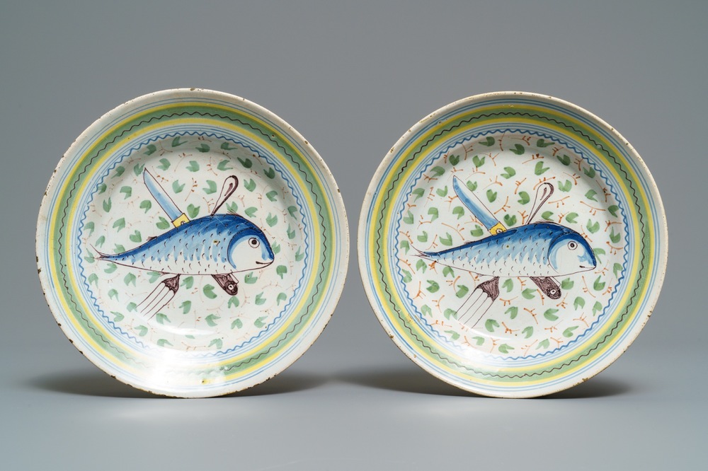 Een paar Brussels aardewerken borden met vis en bestek, 18e eeuw