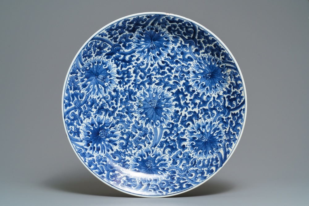 Un grand plat en porcelaine de Chine bleu et blanc &agrave; d&eacute;cor de rinceaux de lotus, Kangxi
