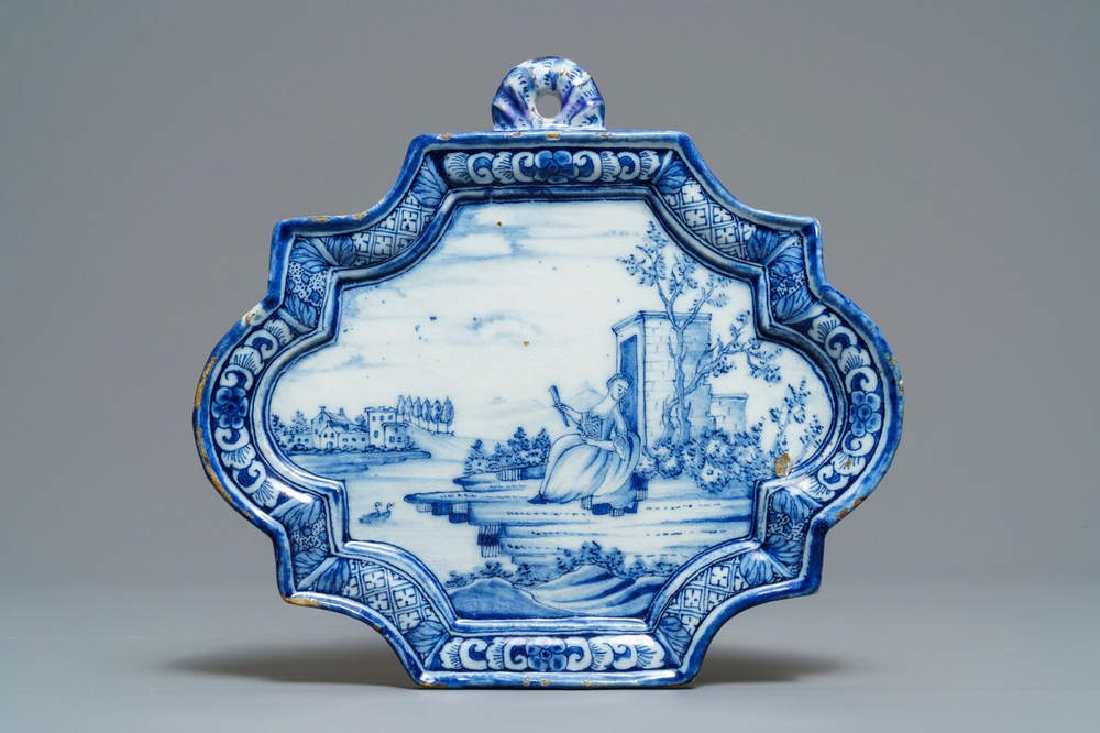 A Dutch Delft blue and white plaque with a lady in a landscape, 18th C.
