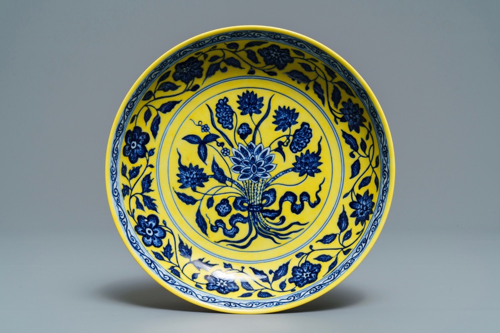 Een Chinees bord met blauwwit boeket van lotusbloemen op gele fondkleur, Qianlong merk, 19/20e eeuw