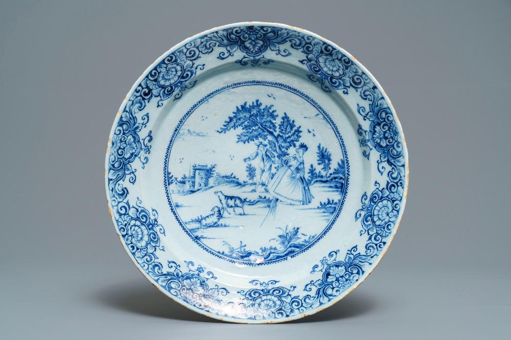 A Dutch Delft blue and white dish with a couple playing blind man's buff, 18th C.