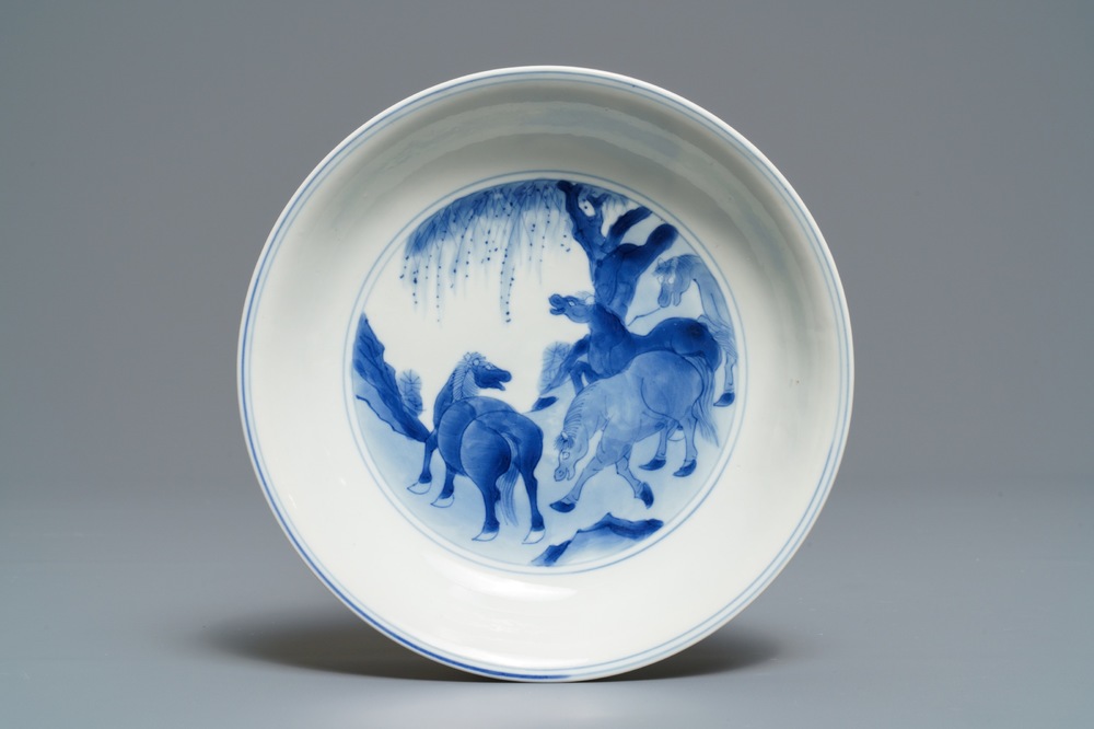 Een Chinees blauwwit bord met 'De acht paarden van Wang Mu', Kangxi merk en periode