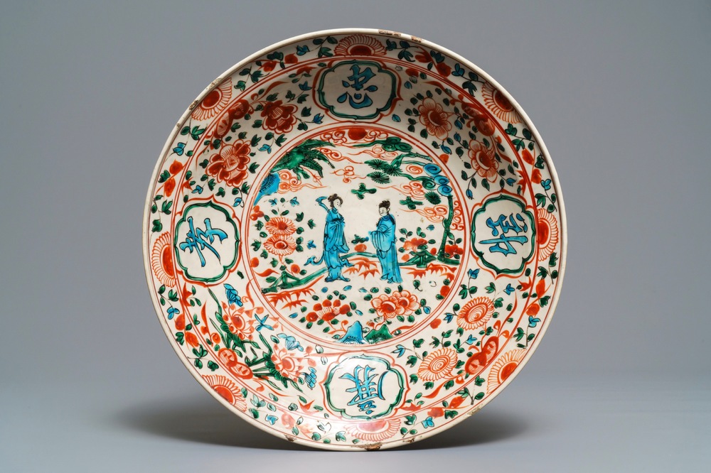 Een Chinese polychrome Swatow schotel met twee figuren in een landschap, Ming