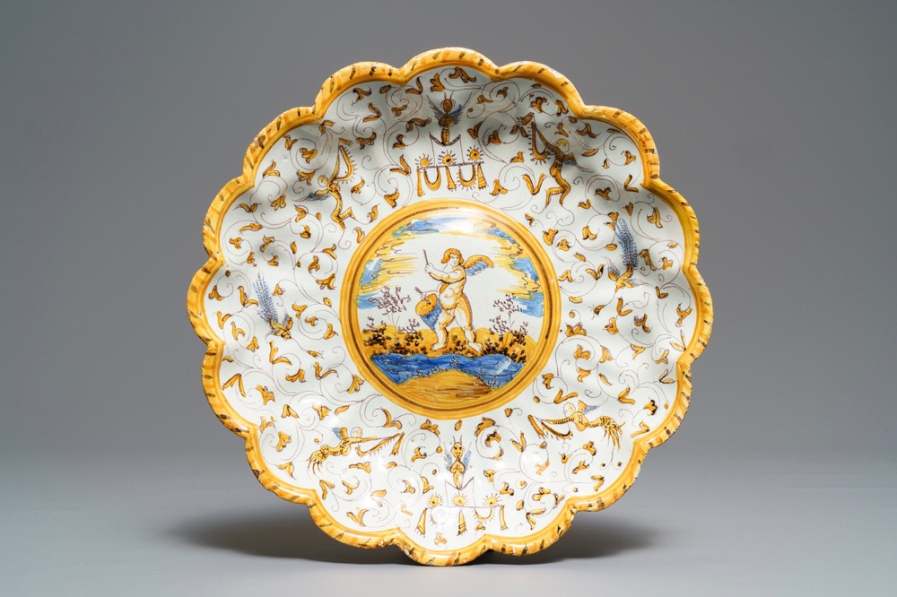 Een gelobde majolica schotel op voet met een putto tussen grotesken, atelier Willem Jansz Verstraeten, Haarlem, ca. 1650