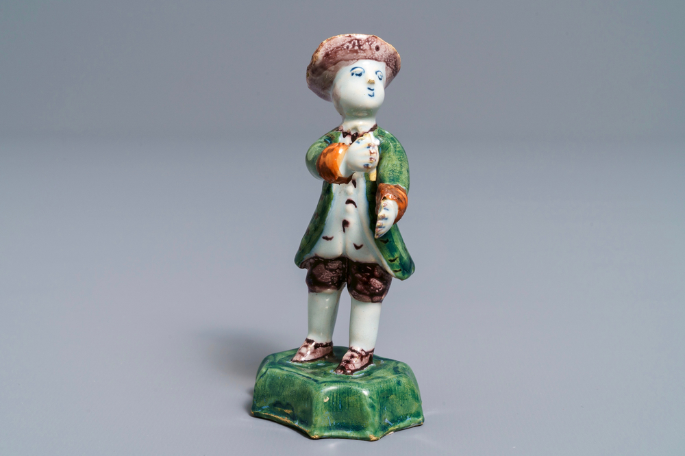A polychrome Dutch Delft figure of a boy with a hat, 18th C.