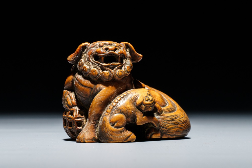 A Japanese carved wood netsuke of a shishi with cub, Edo, 18/19th C.