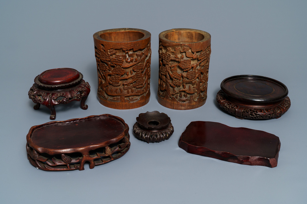 Two Chinese carved bamboo brush pots and five wooden stands, 19/20th C.