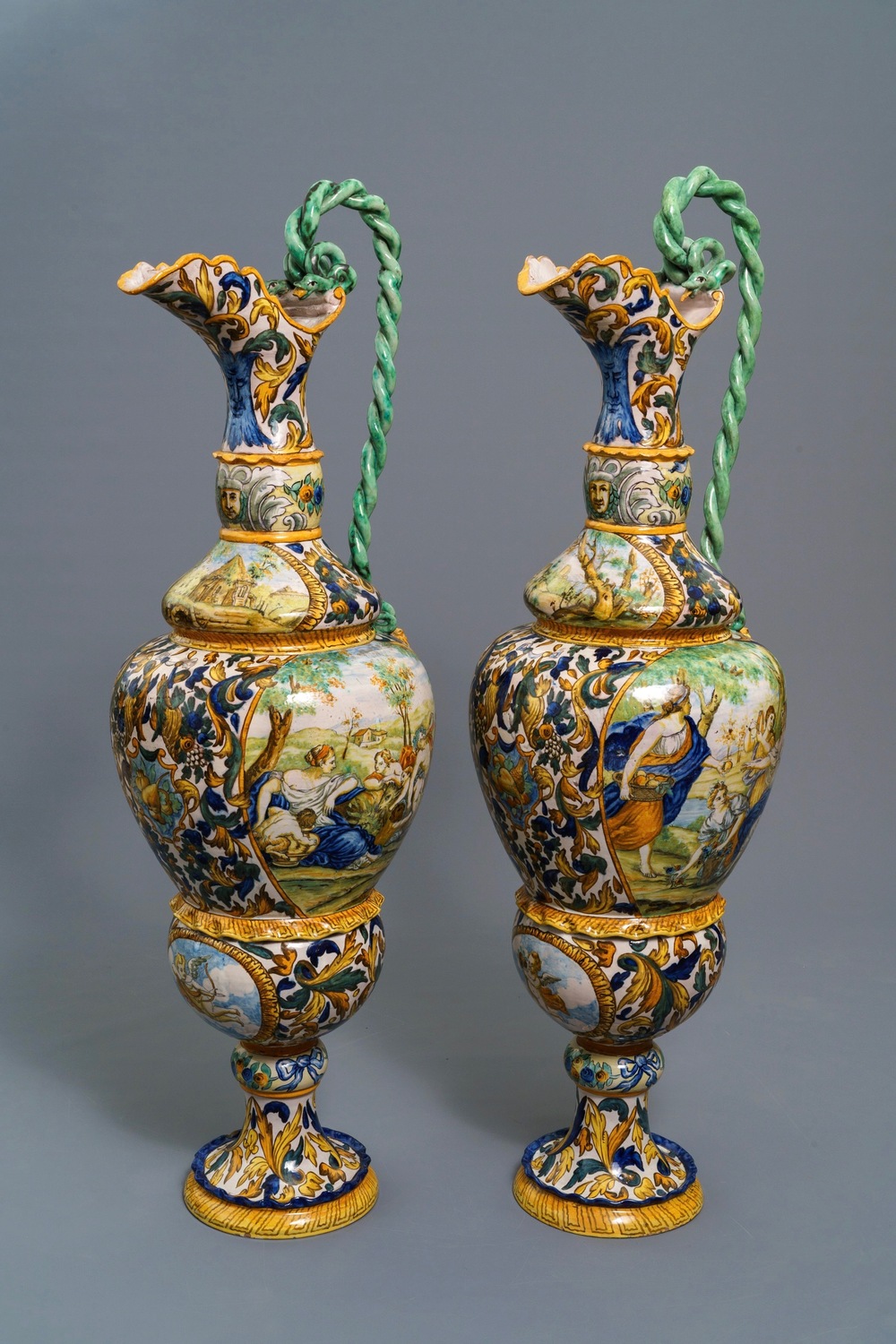 A pair of massive Italian maiolica ewers with figures in landscapes, 19th C.