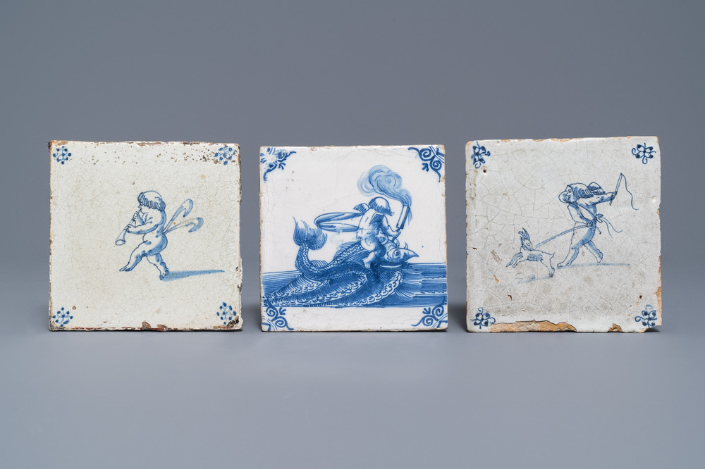 Drie blauw-witte Delftse tegels met putti en een zeemonster, 17e eeuw