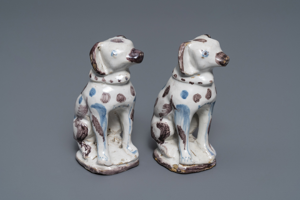 Een paar modellen van zittende honden in blauw-wit en mangaan Brussels aardewerk, 18e eeuw