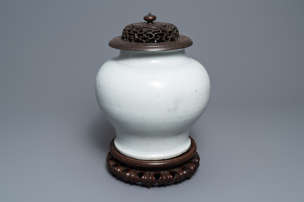 A Chinese monochrome white vase with a wooden cover and stand, Ming