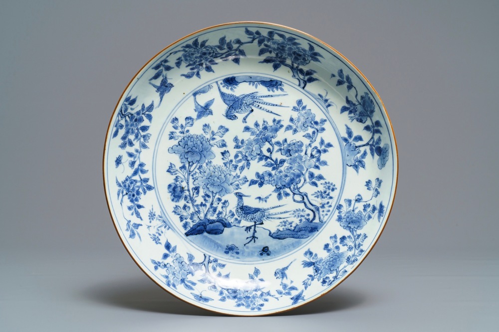 Un plat en porcelaine de Chine bleu et blanc &agrave; d&eacute;cor d'oiseaux parmi branches fleuries, &eacute;poque Transition
