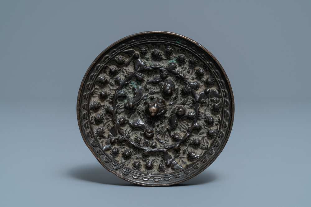 A Chinese bronze mirror with relief design, Tang