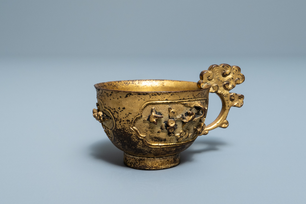 A Chinese relief-decorated gilt bronze cup, Ming