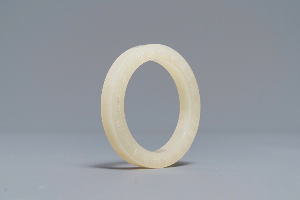 A Chinese inscribed white jade ring, 19/20th C.