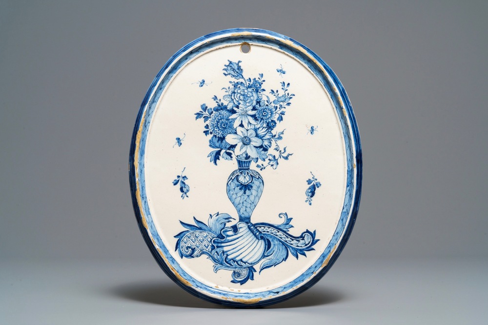 Een fijne ovale blauw-witte Delftse plaquette met gevulde bloemenvaas, 18e eeuw