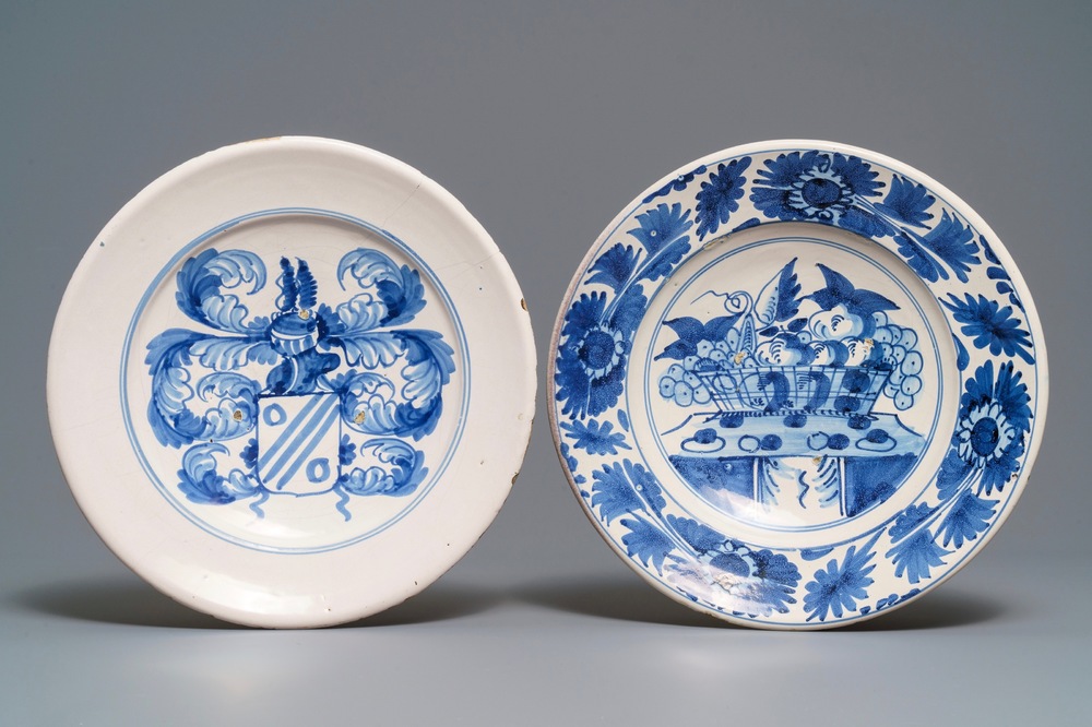 Two blue and white maiolica dishes with a fruit basket and a coat of arms, Delft or Friesland, 17/18th C.