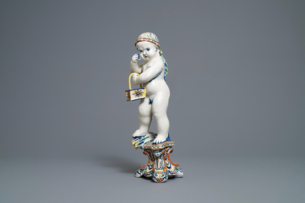 A polychrome Dutch Delft model of a boy, allegory of winter, 18th C.