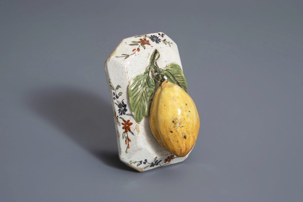 A polychrome Dutch Delft model of a lemon on a base, ca. 1800