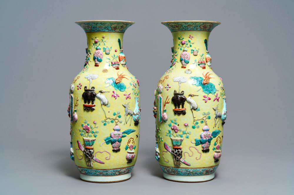 A pair of Chinese yellow-ground famille rose relief-decorated vases, 19th C.