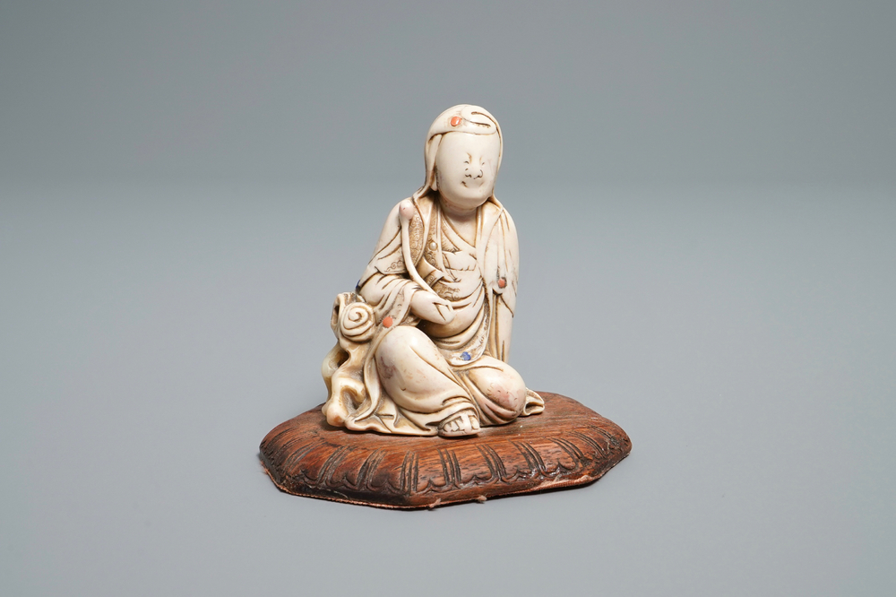 A Chinese inlaid soapstone figure of a seated deity, 17/18th C.