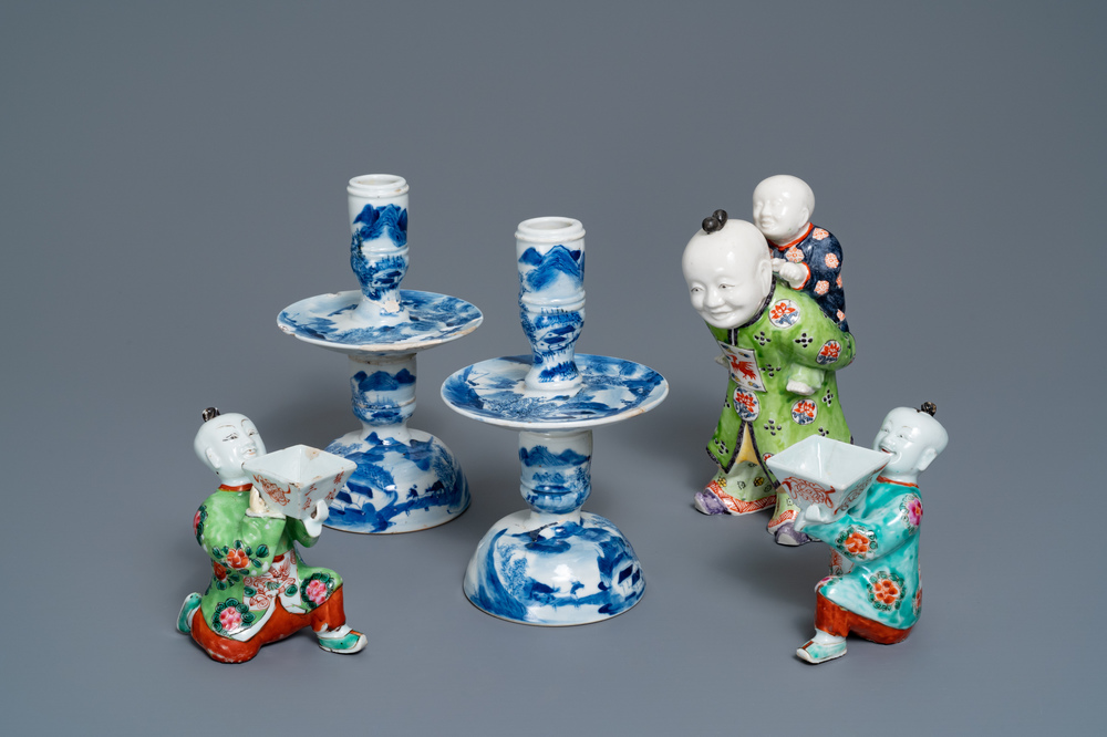 A pair of Chinese blue and white candlesticks and three famille rose figures of boys, 19th C.