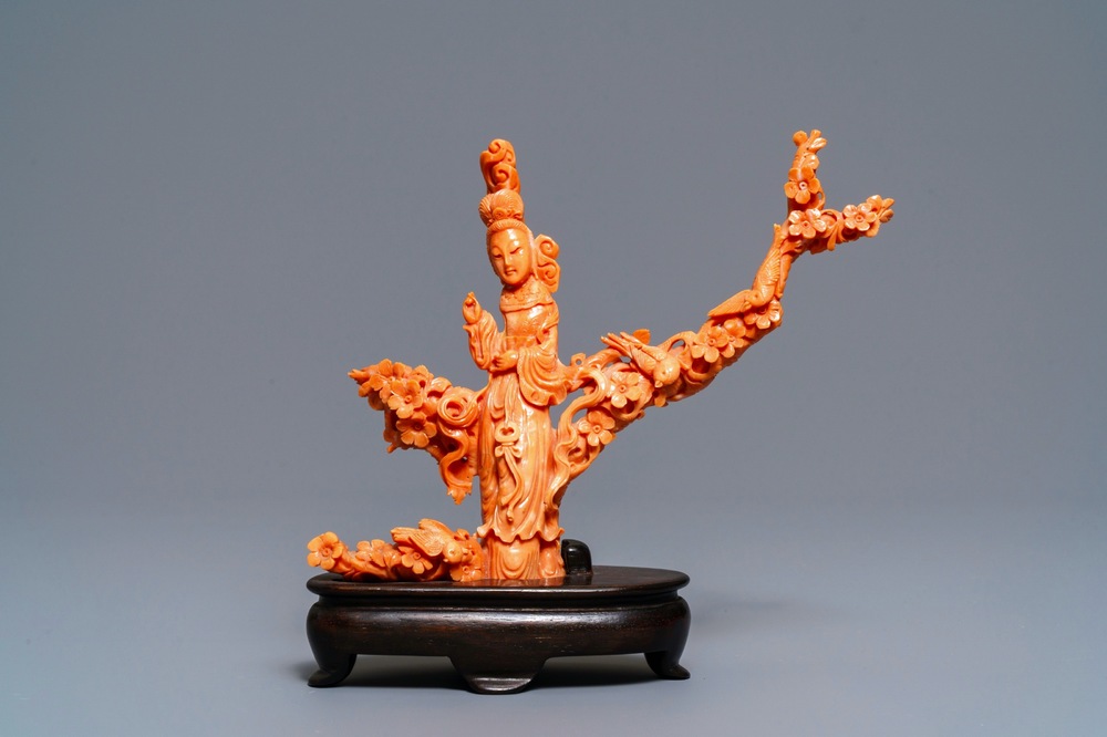 A Chinese carved red coral group of a lady among blossoming branches, 19th C.