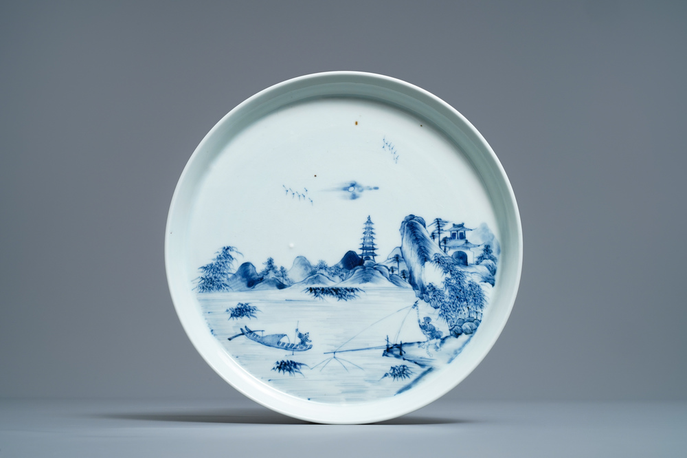 Un plat en porcelaine de Chine en bleu et blanc &agrave; d&eacute;cor d'un paysage riverain, Kangxi/Yongzheng