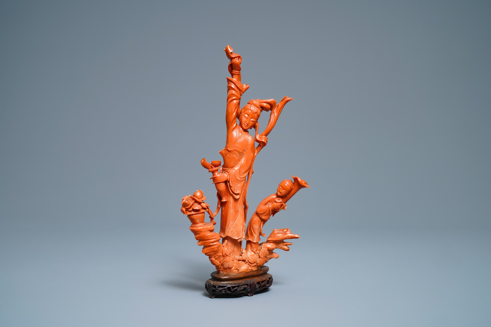 A Chinese carved red coral group of a lady and child, 19th C.