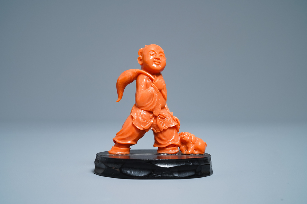 A Chinese carved red coral group of a boy with a dog, 20th C.