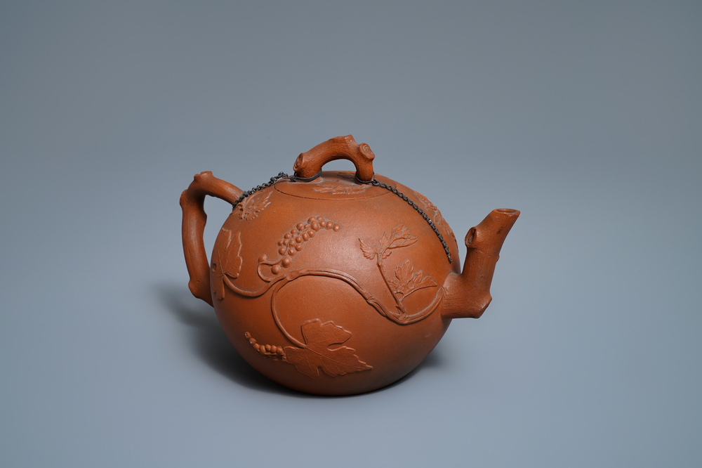 A large Chinese Yixing stoneware teapot with applied grape vines design, Kangxi