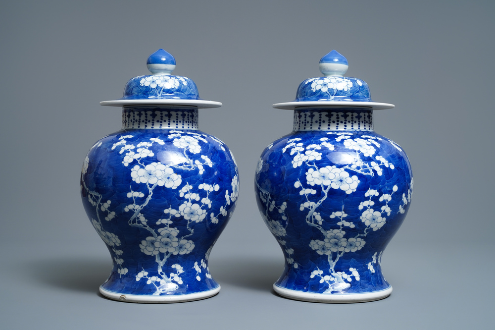 A pair of Chinese blue and white 'prunus on cracked ice' vases and covers, 19th C.