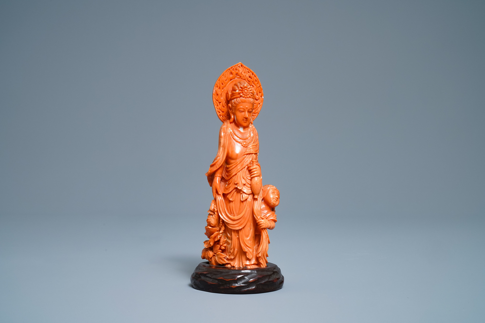 A Chinese carved red coral group of Guanyin with child, 19th C.