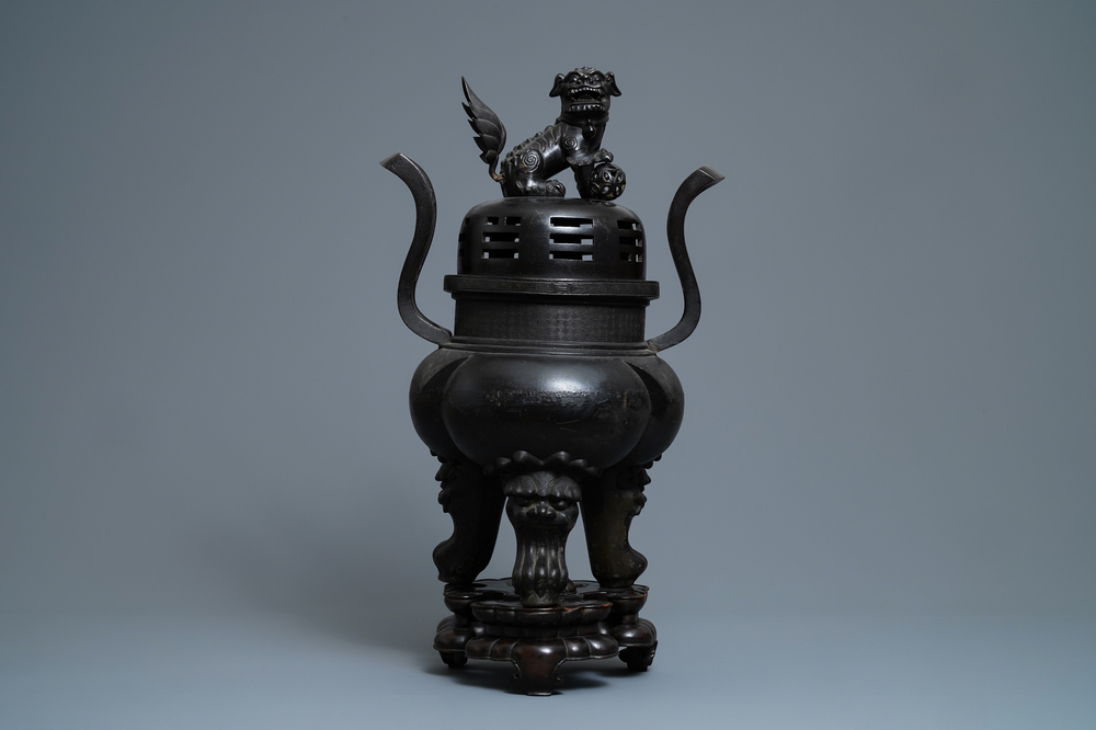 Un grand br&ucirc;le-parfum couvert en bronze sur socle en bois sculpt&eacute;, Chine, Ming