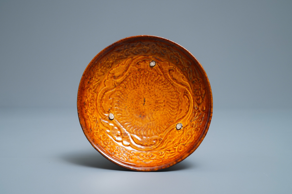 A Chinese amber-glazed relief-decorated saucer dish, Liao (916-1125)