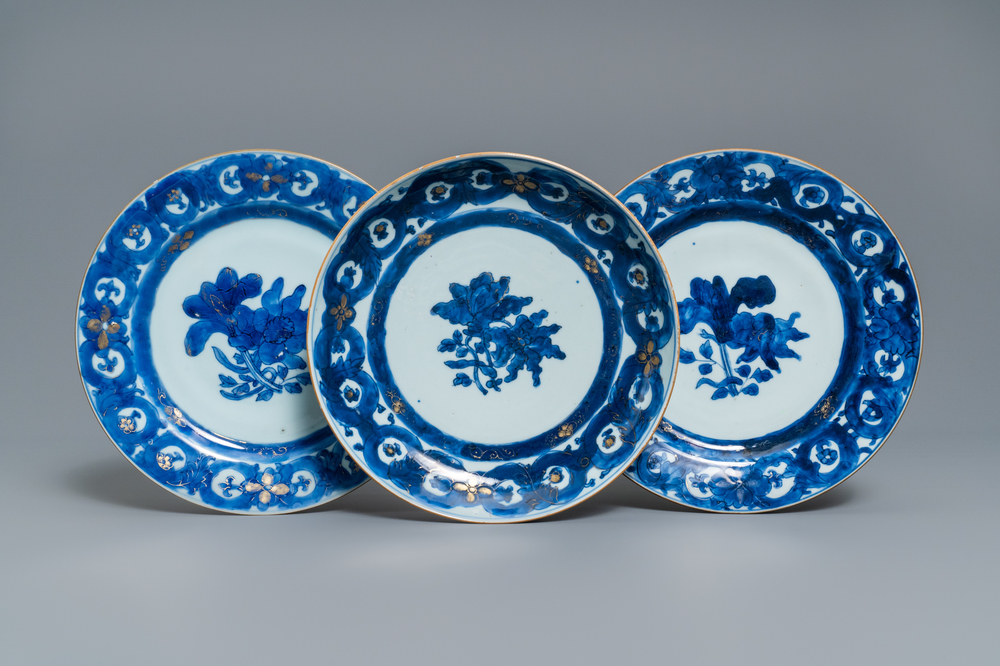 Trois assiettes en porcelaine de Chine en bleu et blanc rehauss&eacute; d'or, Qianlong