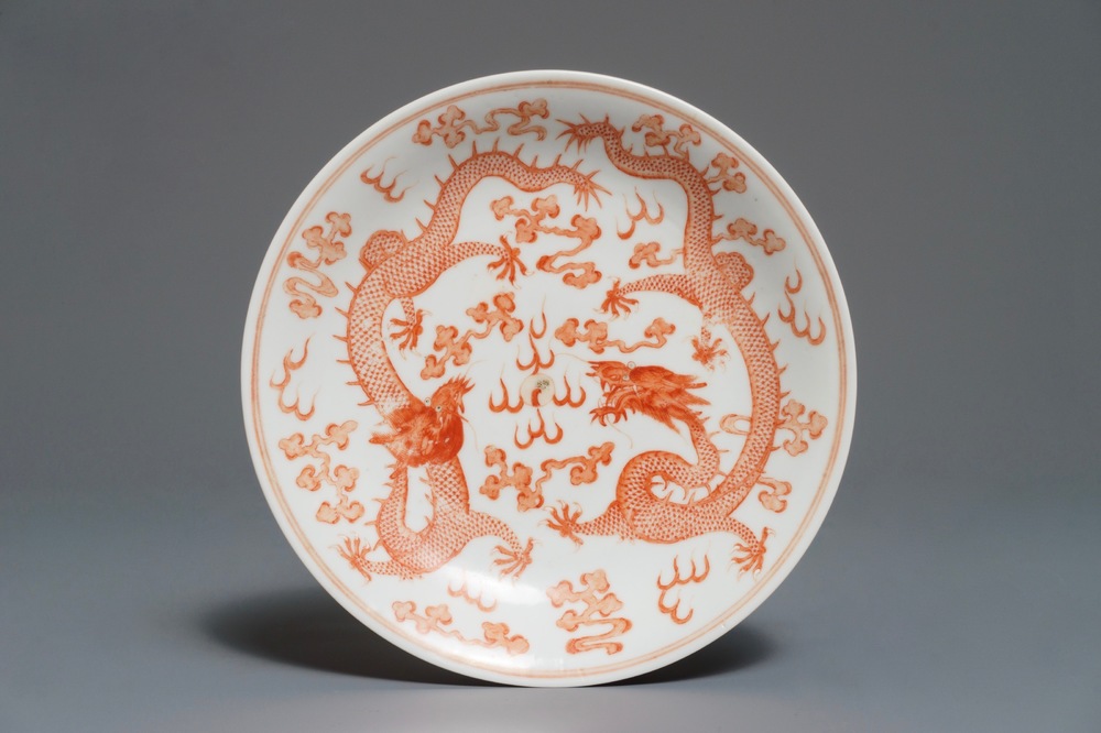 Une assiette aux dragons en porcelaine de Chine rouge de fer au dos rouge de rubis, marque et &eacute;poque de Guangxu