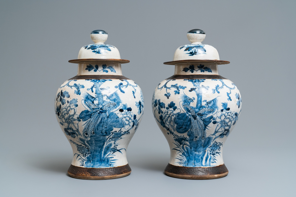 Een paar Chinese blauw-witte Nanking craquel&eacute; dekselvazen, 19e eeuw