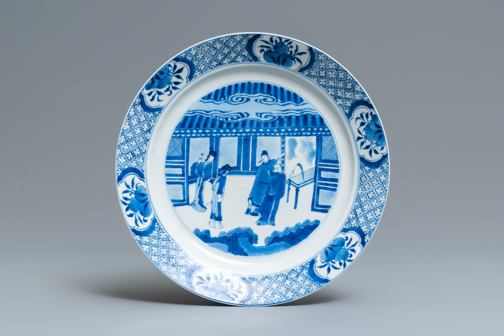 A Chinese blue and white dish with figures in an interior, Kangxi mark and of the period