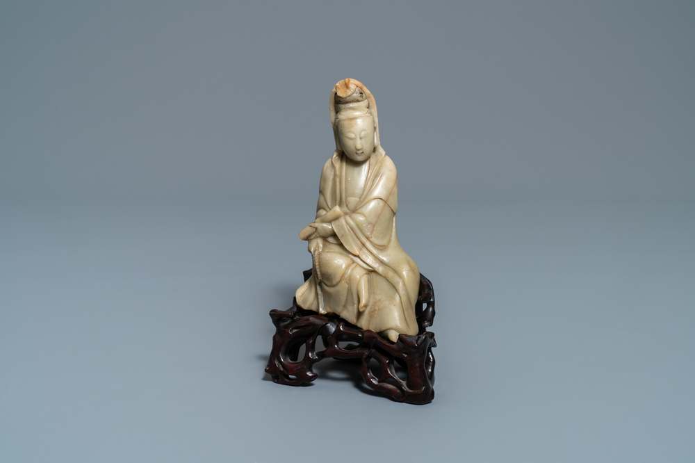 Een Chinees zeepstenen figuur van Guanyin op houten sokkel, 19e eeuw