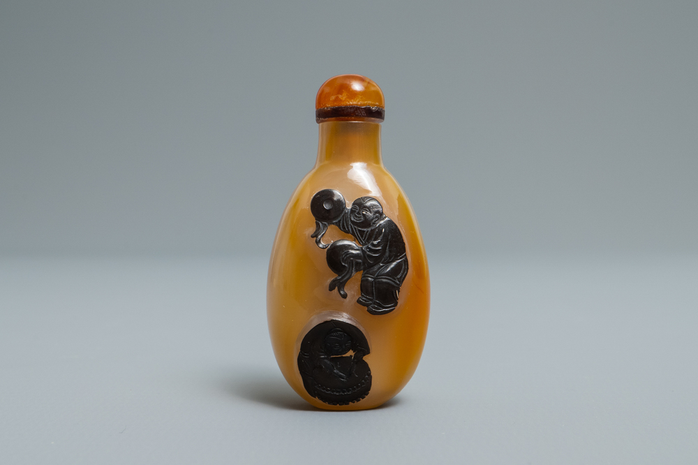 A Chinese carved agate snuff bottle with musicians, 19/20th C.