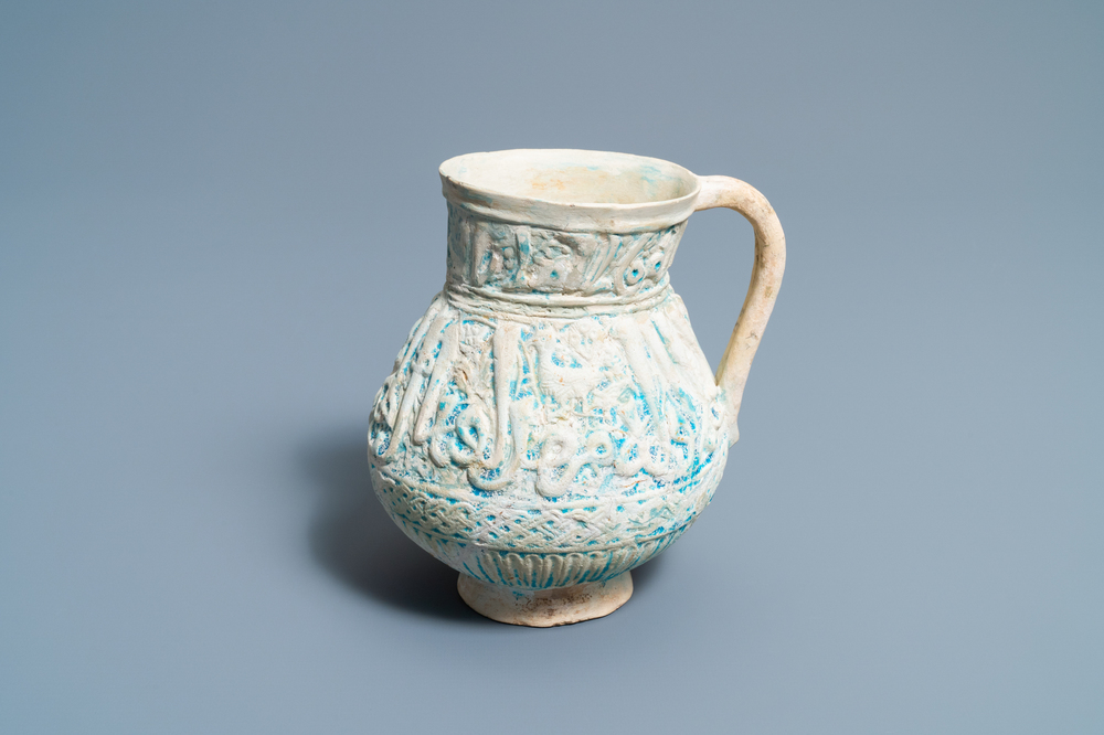 Een Perzische turquoise kan met kalligrafisch reli&euml;fdecor, Kashan, 13/14e eeuw