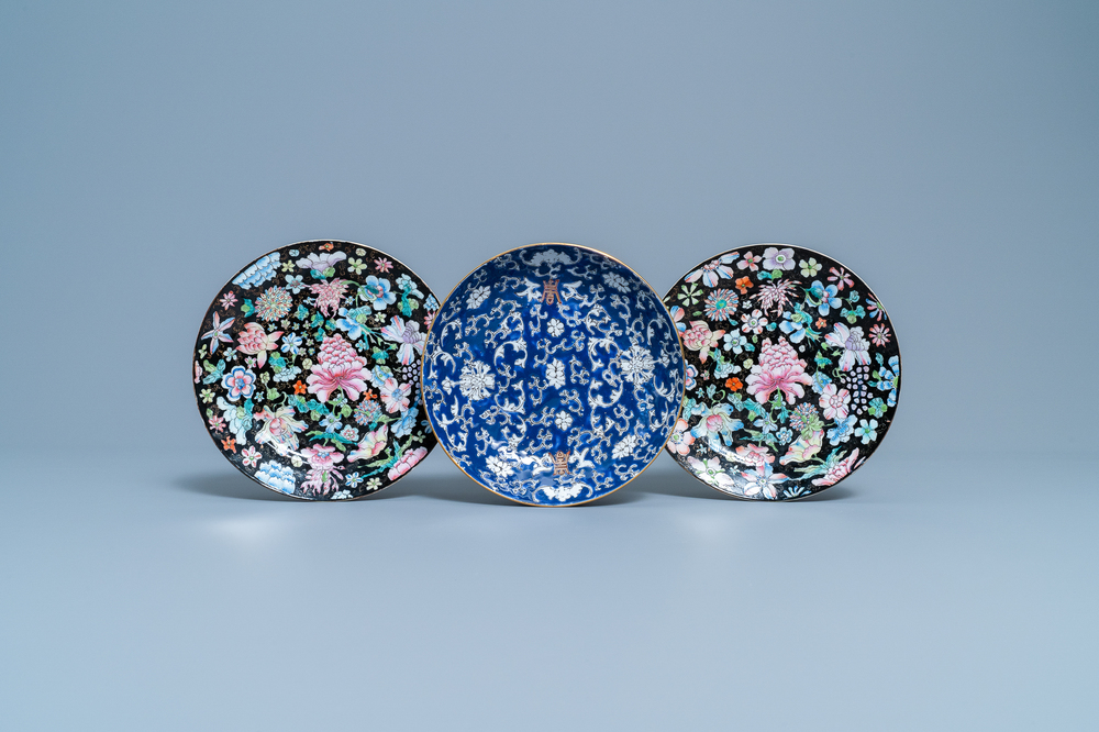 Une paire d'assiettes en porcelaine de Chine famille rose &agrave; d&eacute;cor millefleurs et une &agrave; fond bleu, 19/20&egrave;me