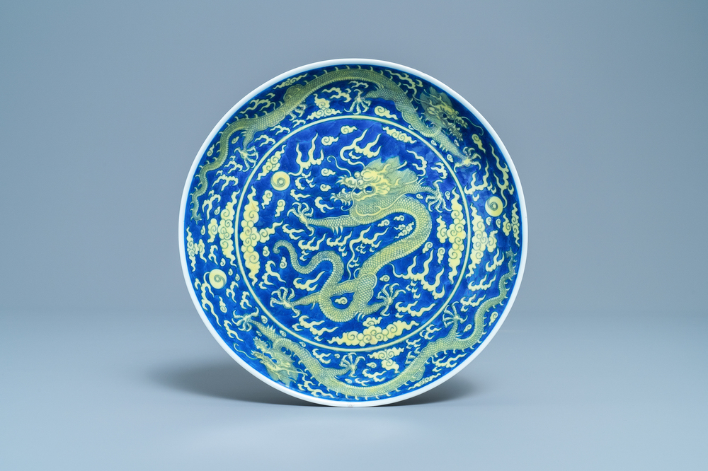 Un plat en porcelaine de Chine en bleu et jaune &agrave; d&eacute;cor d'un dragon, marque et &eacute;poque de Qianlong